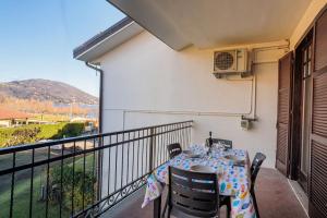 a table and chairs on a balcony with a view at Lake Maggiore Holiday Apartment in Feriolo