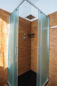 um chuveiro com uma porta de vidro na casa de banho em Lake Maggiore Holiday Apartment em Feriolo