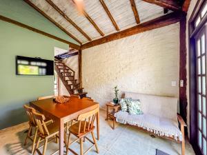 a dining room with a table and a couch at Patio Camburi - Flat com Piscina à 60m da Praia de Camburi in São Sebastião +14 photos