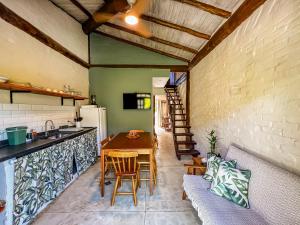 a kitchen and living room with a table and a couch at Patio Camburi - Flat com Piscina à 60m da Praia de Camburi in São Sebastião