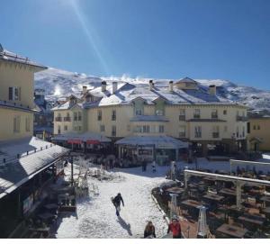 a group of people walking around a town in the snow at Plaza de Andalucía Edificio Salvia con vistas al Veleta in Sierra Nevada