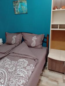 1 dormitorio con cama y pared azul en Top Center Apartment and Rooms Varna, en Varna