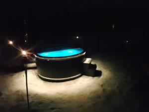 a large tub in the snow at night at BLACK & WHITE HOUSES in Niedzica