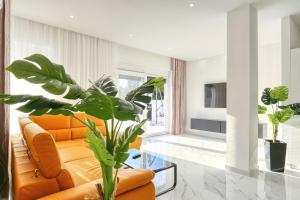 a living room with an orange couch and a glass table at Villa Linda in Zaton