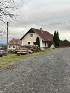 een huis met een stapel houtblokken aan de kant van een weg bij Pohorsko-chata in Pohorsko