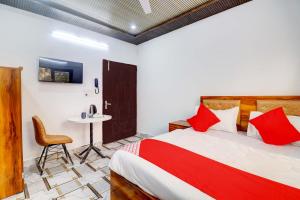 Hotel CG Inn pool rooftop في آغْرا: غرفة نوم بسرير وطاولة وكرسي