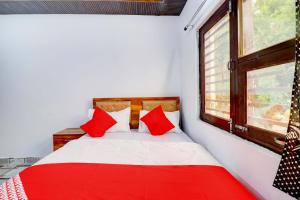 ein rotes und weißes Bett in einem Zimmer mit Fenster in der Unterkunft Hotel CG Inn pool rooftop in Agra