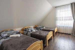 a group of three beds in a room at Apartament w Lasku in Nowy Targ