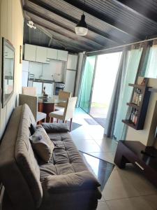 uma sala de estar com um sofá e uma cozinha em Casas Bravo em Itajaí