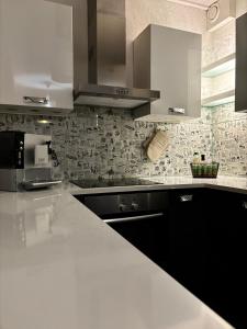 a kitchen with a white counter top and white cabinets at Vartiomaja - beautiful apartment near Arktikum in Rovaniemi