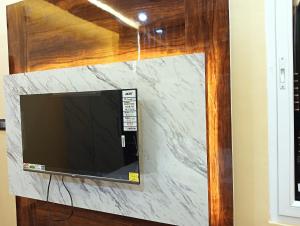 a flat screen tv mounted to a wall at Hotel Ashok Vihar in Bhabua