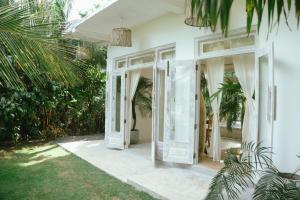 una puerta abierta a una casa blanca con plantas en Pantera Lake House, en Ahangama