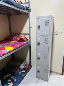 um quarto com 2 beliches ao lado de um cacifo em UAE HOSTEL em Dubai
