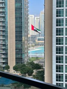 una bandera roja ondeando frente a edificios altos en Stylish New 2BR l Spacious with Burj & Fountain Views l near Dubai Mall l Pool l Gym en Dubái