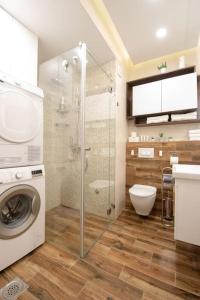 a bathroom with a washing machine and a shower at Yellow Sky Apartment * Spacious with free parking in Novi Sad