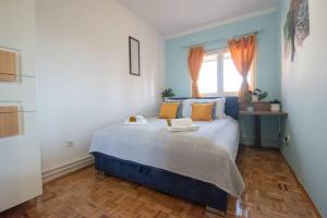 a blue bed in a room with a window at Yellow Sky Apartment * Spacious with free parking in Novi Sad