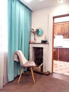 ein Wohnzimmer mit einem Stuhl und einem Kamin in der Unterkunft Бирюзовый стиль in Tschernihiw