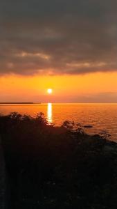 a sunset over the ocean with the sun setting at Zua Bungalow in Pazar