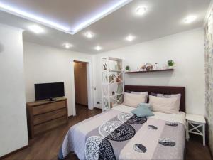 sypialnia z łóżkiem i telewizorem w obiekcie Бирюзовый стиль w mieście Czernihów