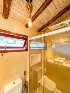 a bathroom with a glass shower and a toilet at Patio Camburi - Flat com Piscina à 60m da Praia de Camburi in São Sebastião