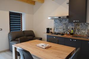 a kitchen with a wooden table with chairs and a stove at Manuel Guesthouse Ravascletto in Ravascletto