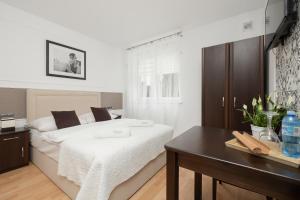 a bedroom with a bed with a table and a desk at Zwierzyńscy Residence in Pobierowo