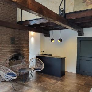 a room with chairs and a table and a brick wall at Architektenhaus am Waldrand mit Sauna in Schwabach