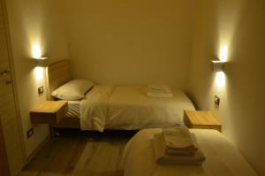a small room with two beds and two lights at Manuel Guesthouse Ravascletto in Ravascletto