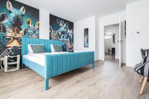 Un dormitorio con una cama azul con una pintura de cebras en Naomi & Sophia Apartman, en Budapest