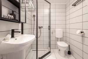 Un baño con ducha, lavabo e inodoro. en Naomi & Sophia Apartman, en Budapest 25 fotos más