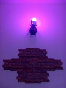 una luz en una pared de ladrillo con una escalera de ladrillo en A Home away From Home By Alex Appartamento Malpensa Prestige Residence en Busto Arsizio
