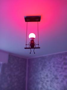una luz colgando del techo con una luz roja en A Home away From Home By Alex Appartamento Malpensa Prestige Residence en Busto Arsizio