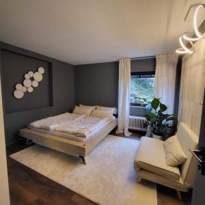 a bedroom with a bed and a chair and a window at Architektenhaus am Waldrand mit Sauna in Schwabach