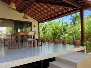 een patio met een tafel en stoelen bij Casa Gemini in Ilha de Boipeba