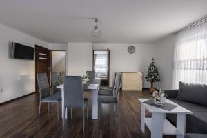 a living room with a table and chairs and a couch at Apartament w Lasku in Nowy Targ