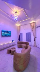 a living room with a couch and a flat screen tv at Geminge shortlet in Port Harcourt