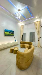 a living room with a couch and two ottoman at Geminge shortlet in Port Harcourt