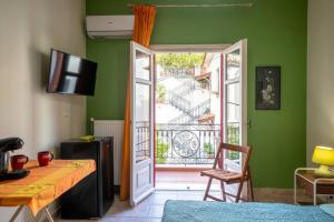 Grünes Zimmer mit einer Tür, die auf einen Balkon führt. in der Unterkunft Delphian Colors - Orange Edition in Delphi