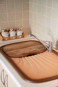 a wooden sink with a faucet on top of it at Delphian Colors - Orange Edition in Delphi