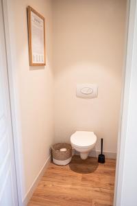 a small bathroom with a toilet and a basket at La Blanchère, vue golf in Vedène