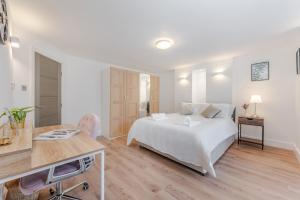 um quarto branco com uma cama e uma secretária em A Golden Haven Retreat in London em Londres
