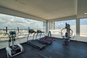 a gym with several tread machines in a room with windows at Lujoso Apartamento S802 Downtown Santo Domingo in Santo Domingo