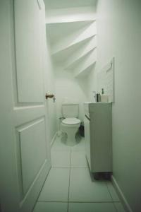 a white bathroom with a toilet and a sink at Bagualita Patagonia in Coihaique