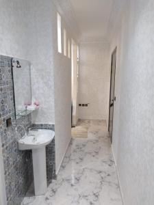 La salle de bains blanche est pourvue d'un lavabo et d'un miroir. dans l'établissement Agadir Tranquility : Cozy Pad, à Agadir