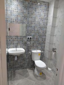 La salle de bains est pourvue de toilettes et d'un lavabo. dans l'établissement Agadir Tranquility : Cozy Pad, à Agadir