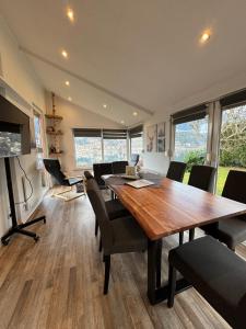 uma sala de jantar com uma grande mesa de madeira e cadeiras em Kantor Lodges & Chalets em Millstatt