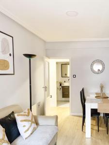 een woonkamer met een witte bank en een tafel bij Apartamento moderno y céntrico en Huesca ciudad in Huesca