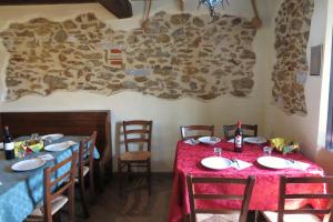 a dining room with two tables and chairs and a stone wall at B&B Dal Brillante in Seravezza