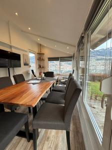 uma sala de jantar com uma longa mesa de madeira e cadeiras em Kantor Lodges & Chalets em Millstatt