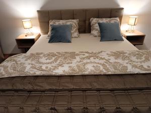 a bed with two pillows and two lamps on tables at Apartmán Mimi in Liptovský Mikuláš